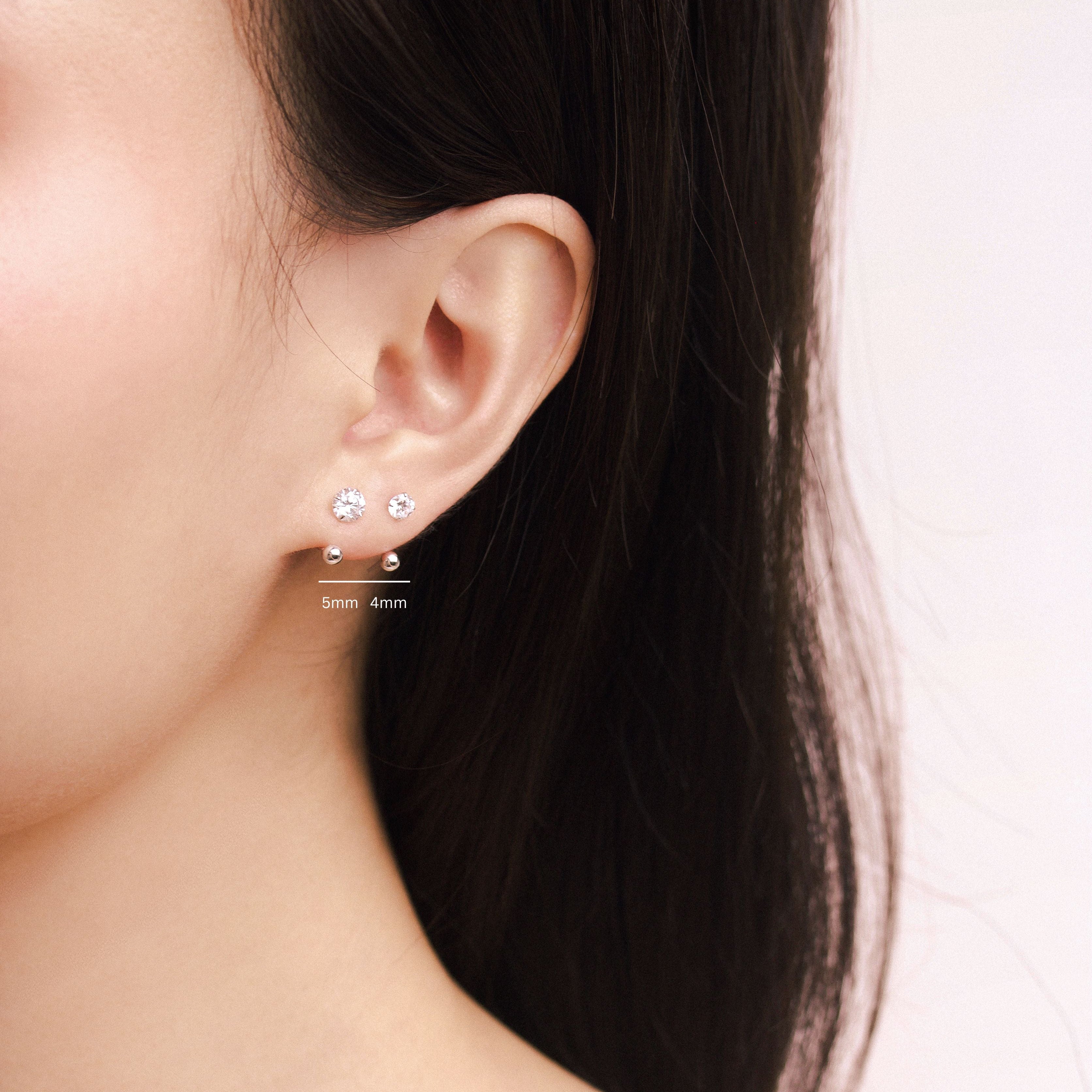 Fine jewellery, silver jewellery, hypoallergenic, tarnish-free, Front view Close-up of a person wearing a crystal earring with silver spherical ends, labelled with 4mm and 5mm of different crystal size