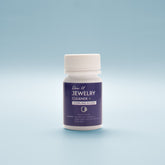 Close-up front view Jewellery cleaner bottle with blue label on a light blue background