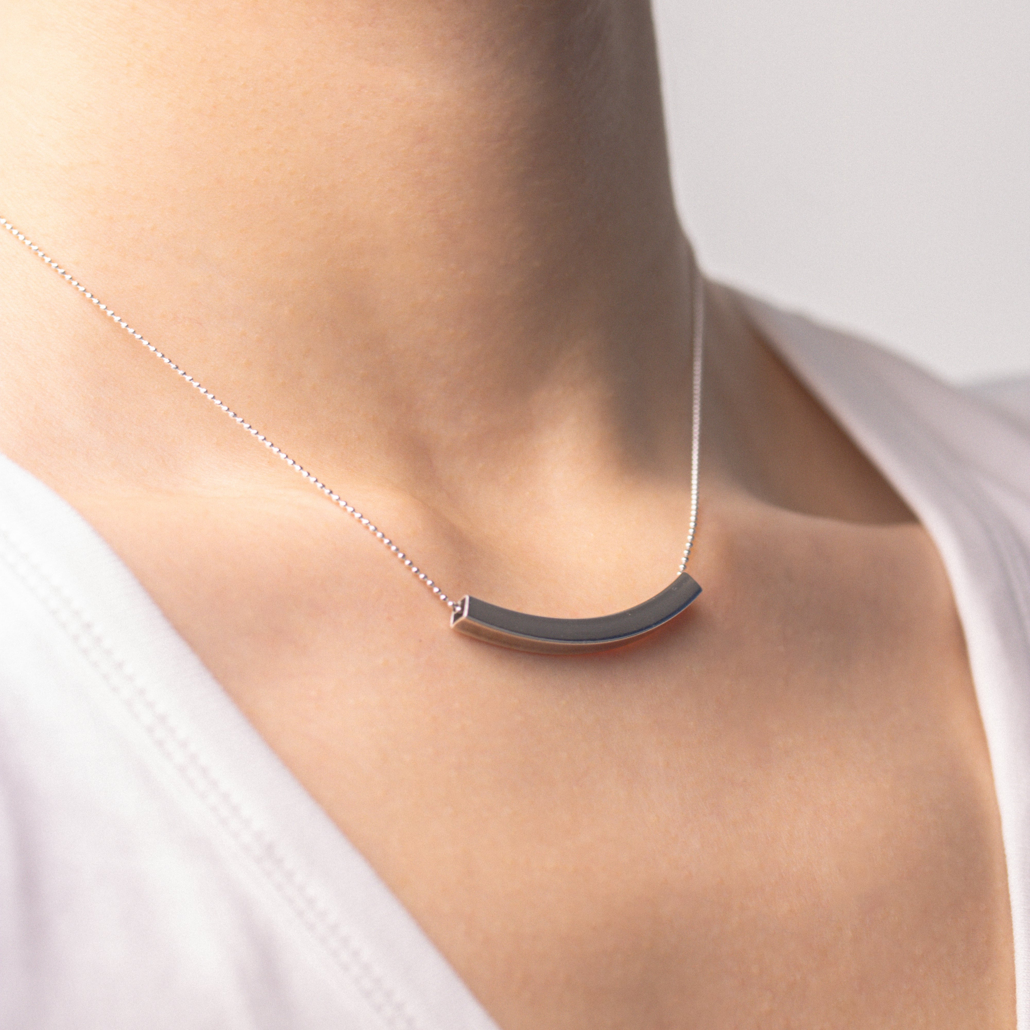 Fine silver jewellery, silver necklace, Pendant necklace, Hypoallergenic, Tarnish-free , close up Side view of a silver pendant necklace on a person wearing a white top against a light background