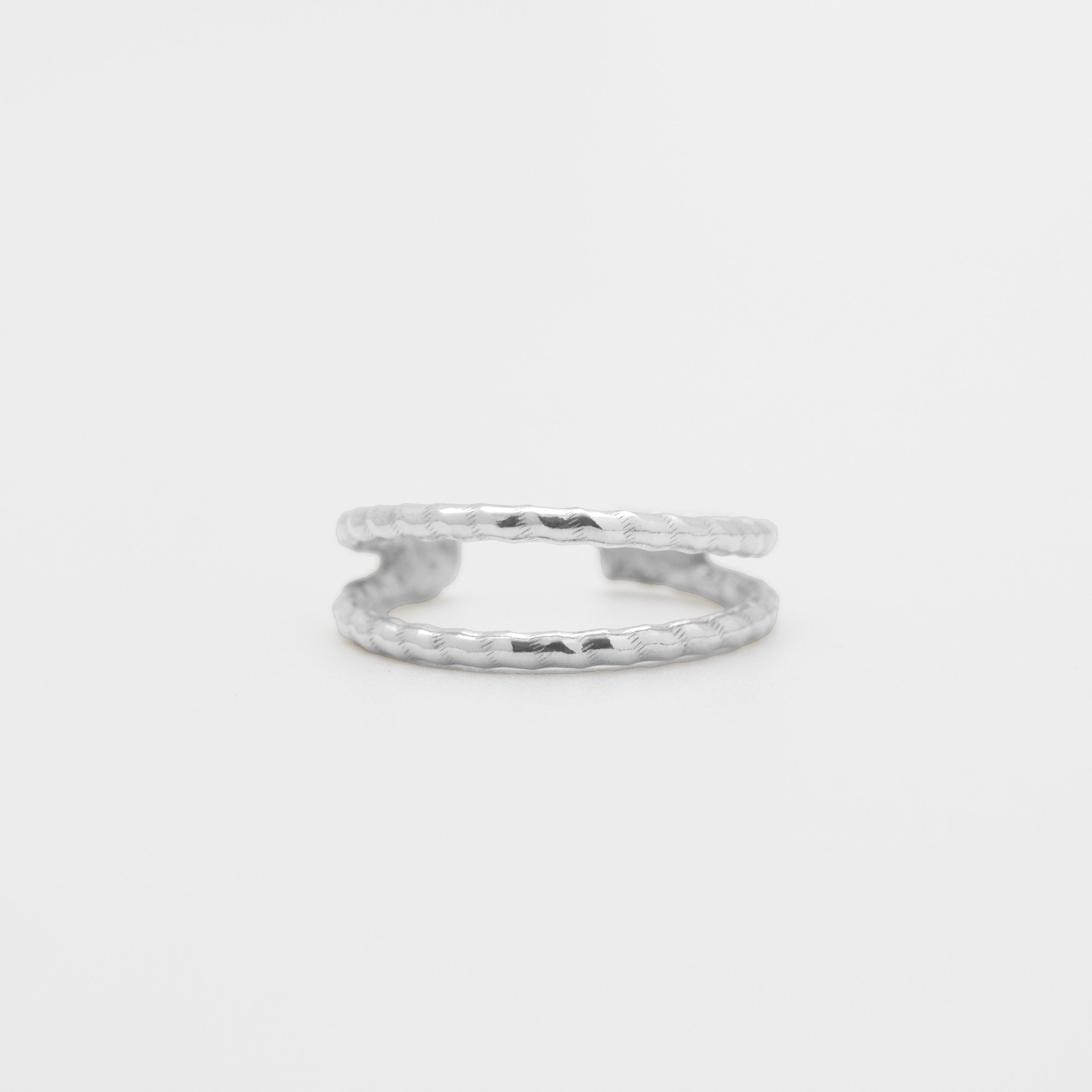 Silver ring on a light gray background, close up front view