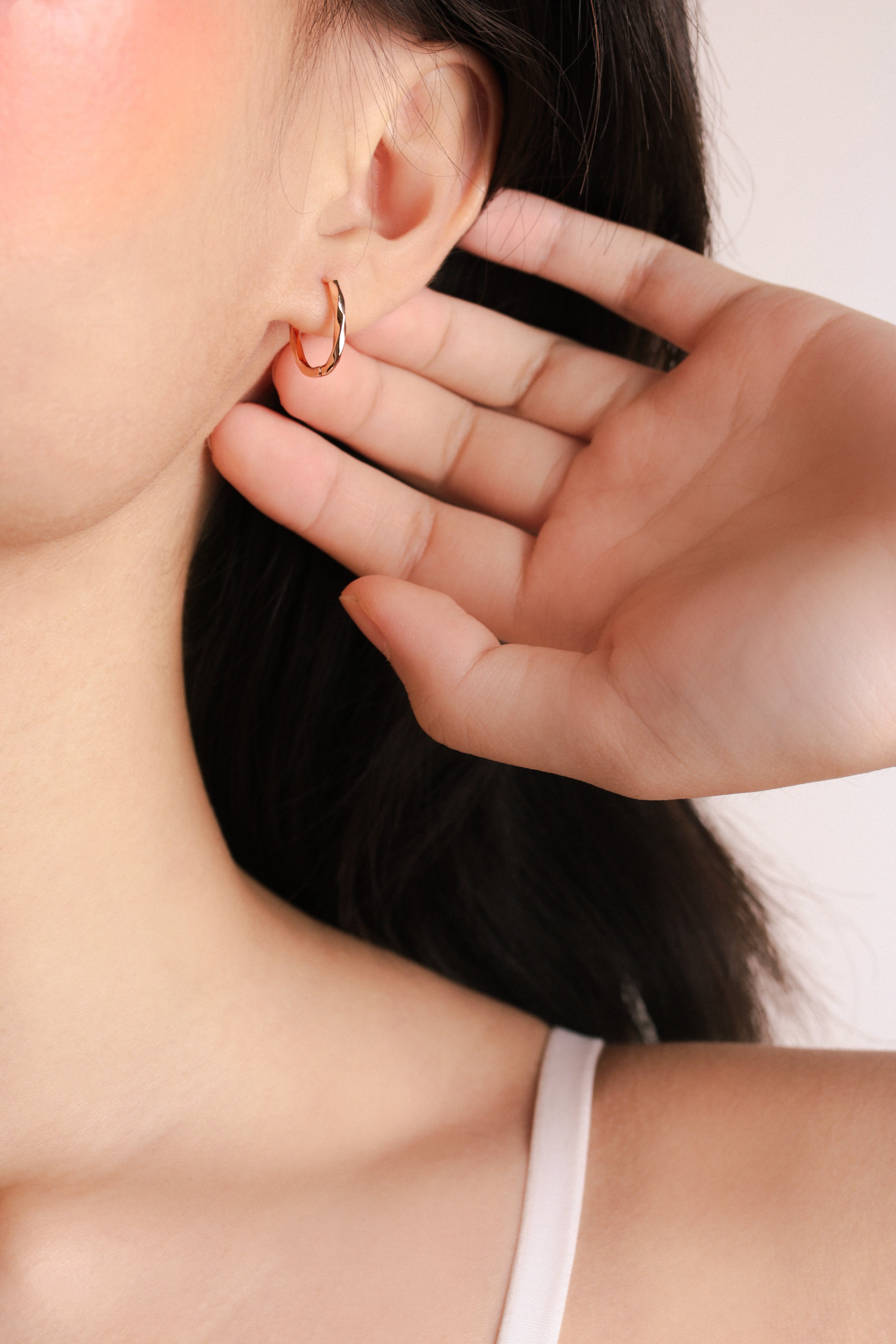 Fine jewellery, silver jewellery plated with rose gold, hypoallergenic, tarnish-free, full side view of a Rose gold hoop earrings on worn on a person's ear