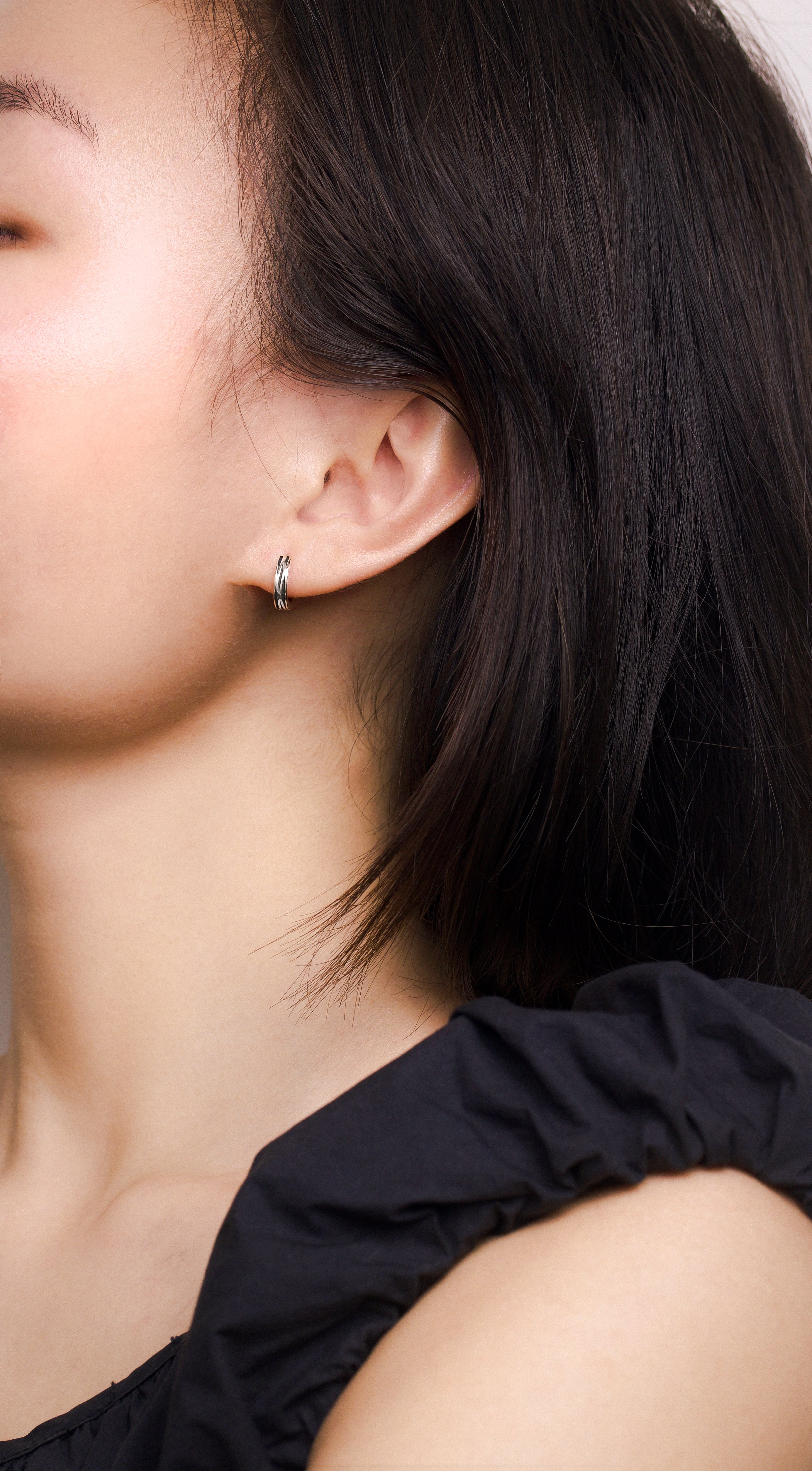 Fine jewellery, silver jewellery, hypoallergenic, tarnish-free, full front view of a silver glazed black hoop earrings worn on a person's ear