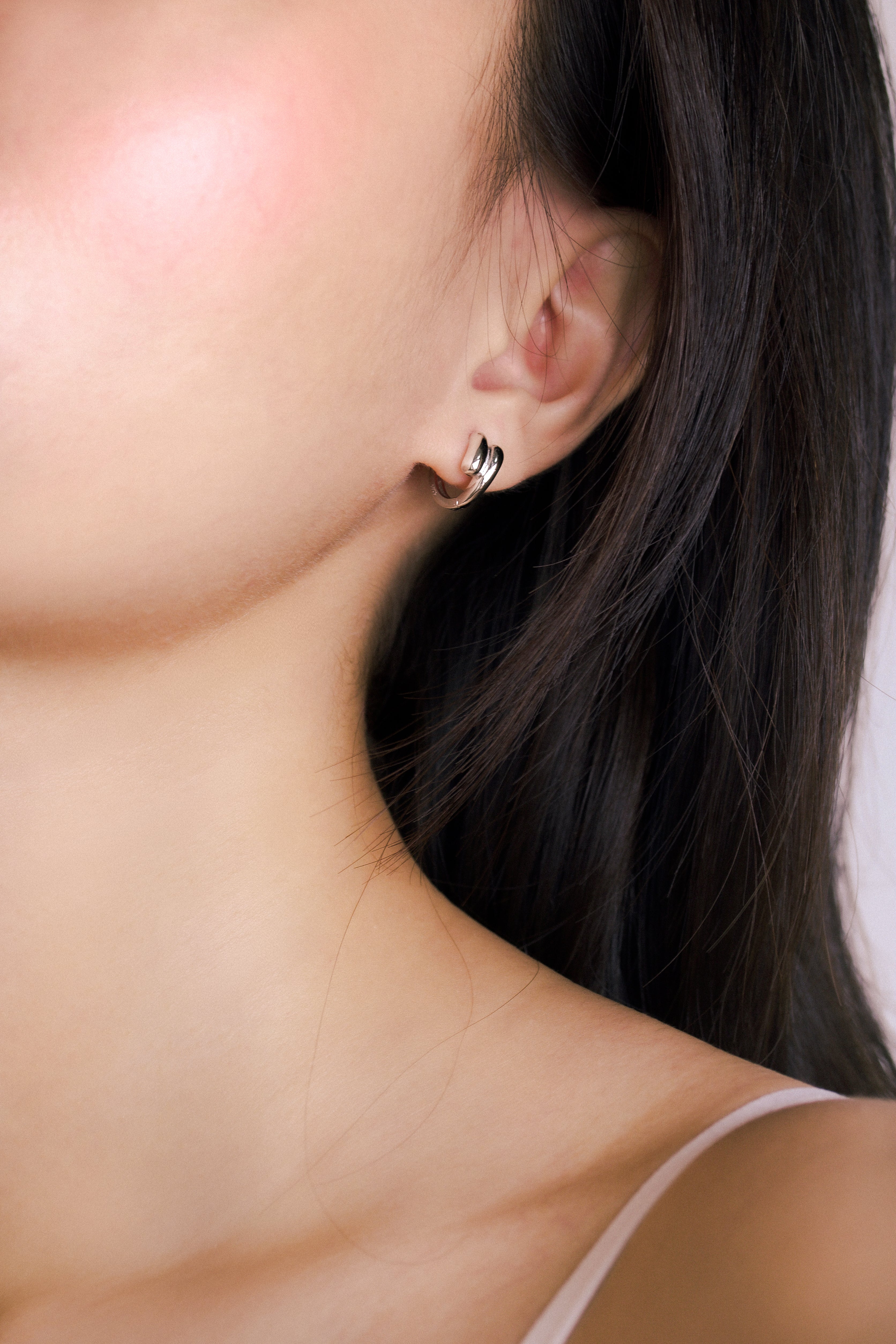 Fine jewellery, silver jewellery, hypoallergenic, tarnish-free,
full side view of a person wearing a silver hoop earring.