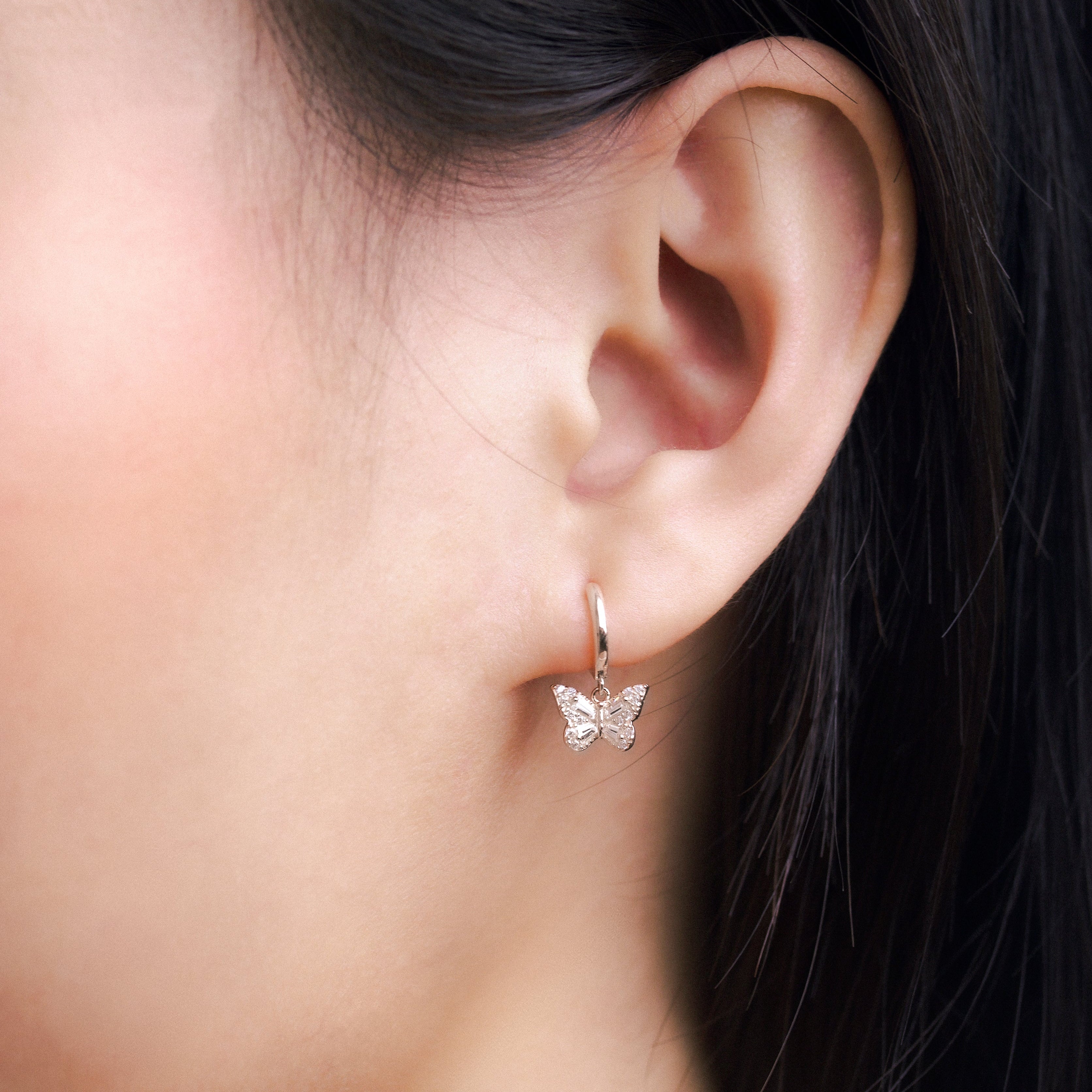 Fine jewellery, silver jewellery, hypoallergenic, tarnish-free, close-up front view of a Butterfly-shaped earring worn by a person with dark hair.