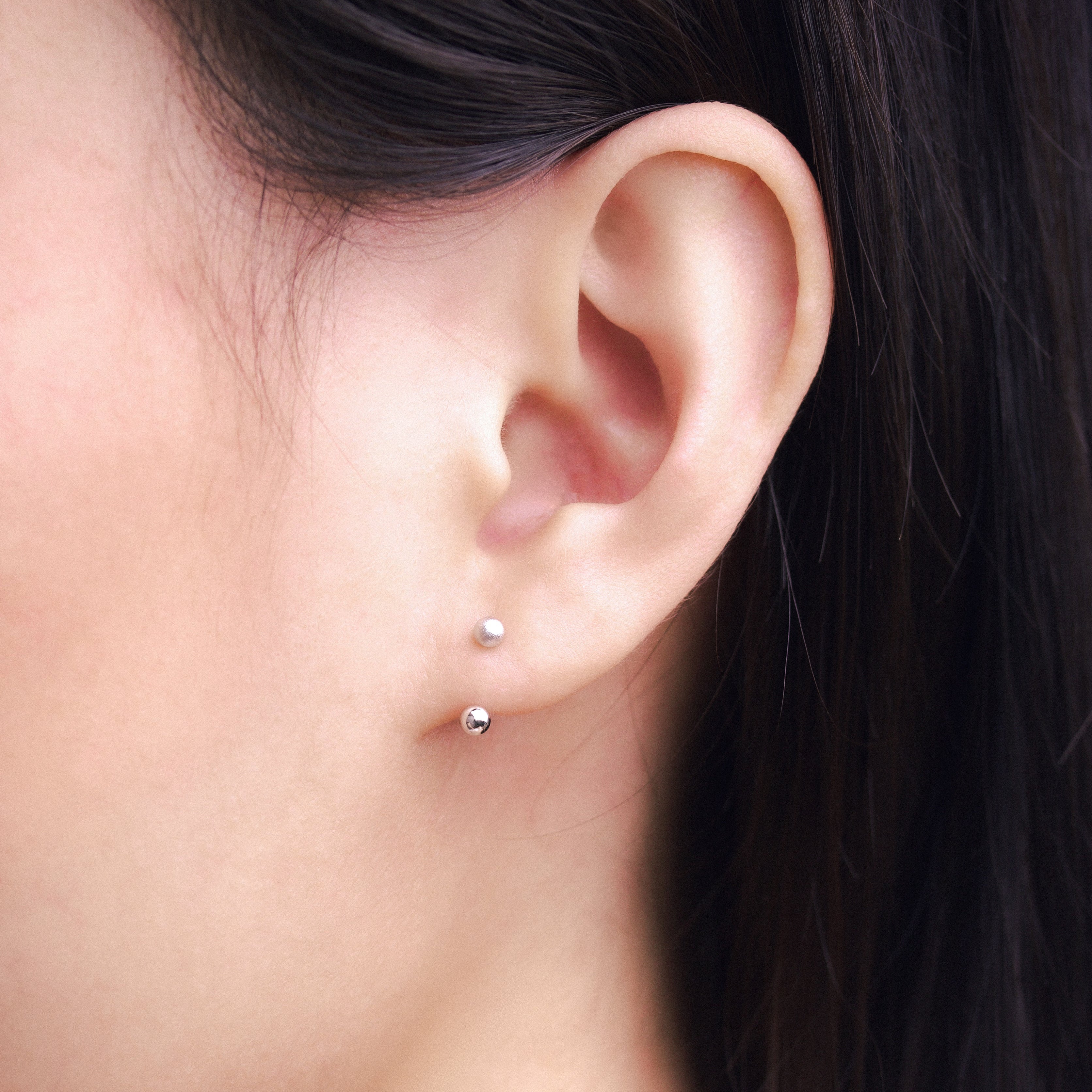 Fine jewellery, silver jewellery, hypoallergenic, tarnish-free, Close-upm side view of an ear with a small silver earring stud.