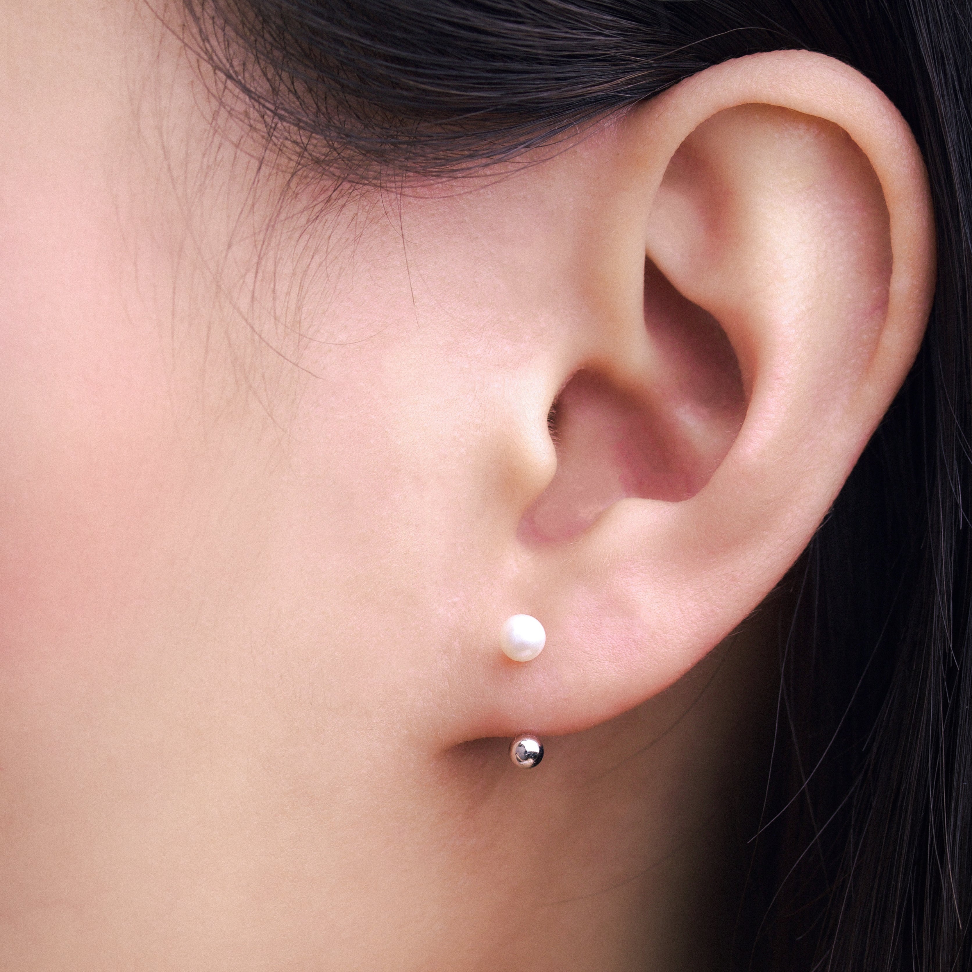 Fine jewellery, silver jewellery, hypoallergenic, tarnish-free, Close-up of an ear wearing a pearl earring with a silver spherical end