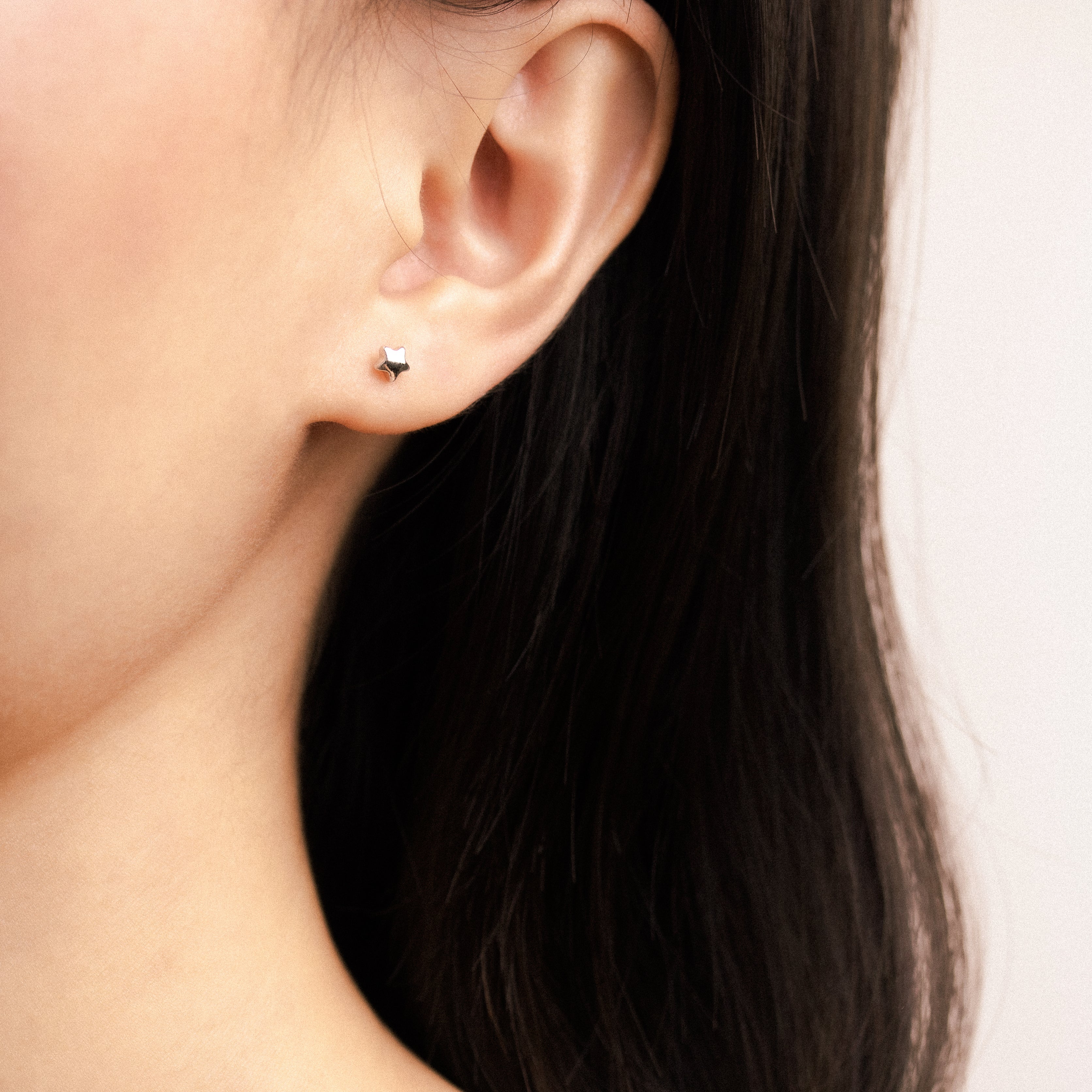 Fine jewellery, silver jewellery, hypoallergenic, tarnish-free,
full front view of a Star-shaped earrings worn on a person's ear