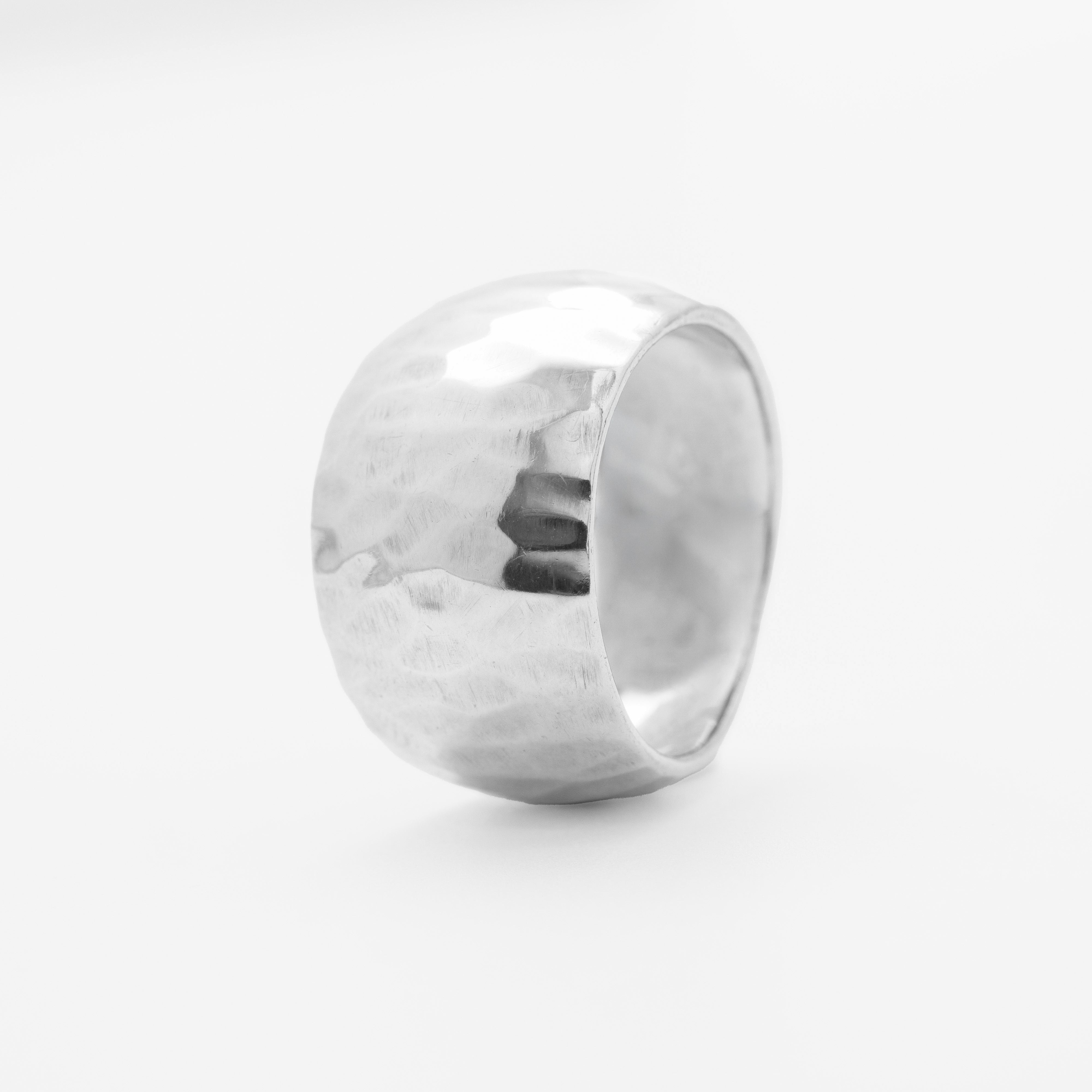Silver ring with a textured surface on a white background, close-up front view