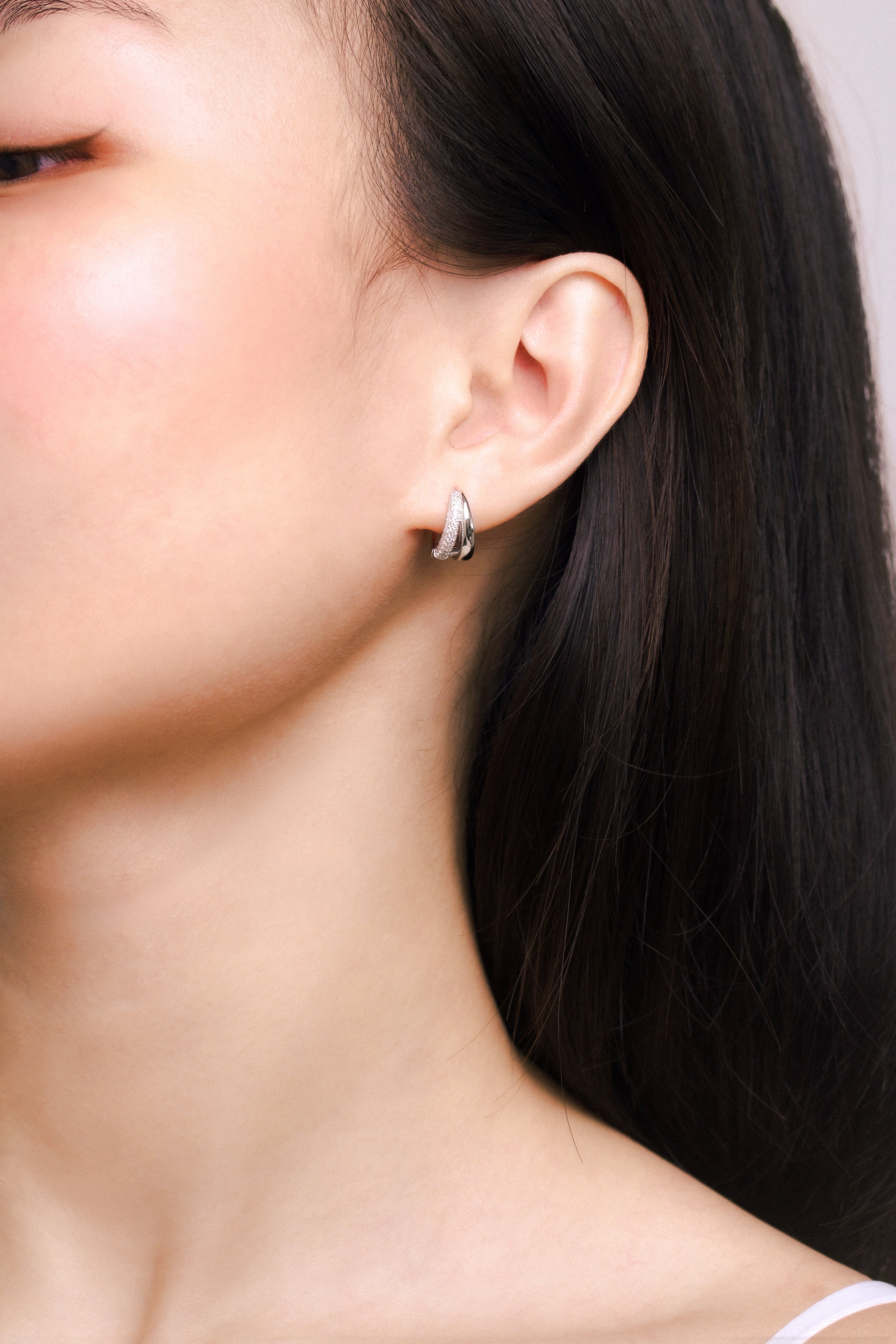 Fine jewellery, silver jewellery, hypoallergenic, tarnish-free, full front view of a person wearing a silver earring with a neutral background