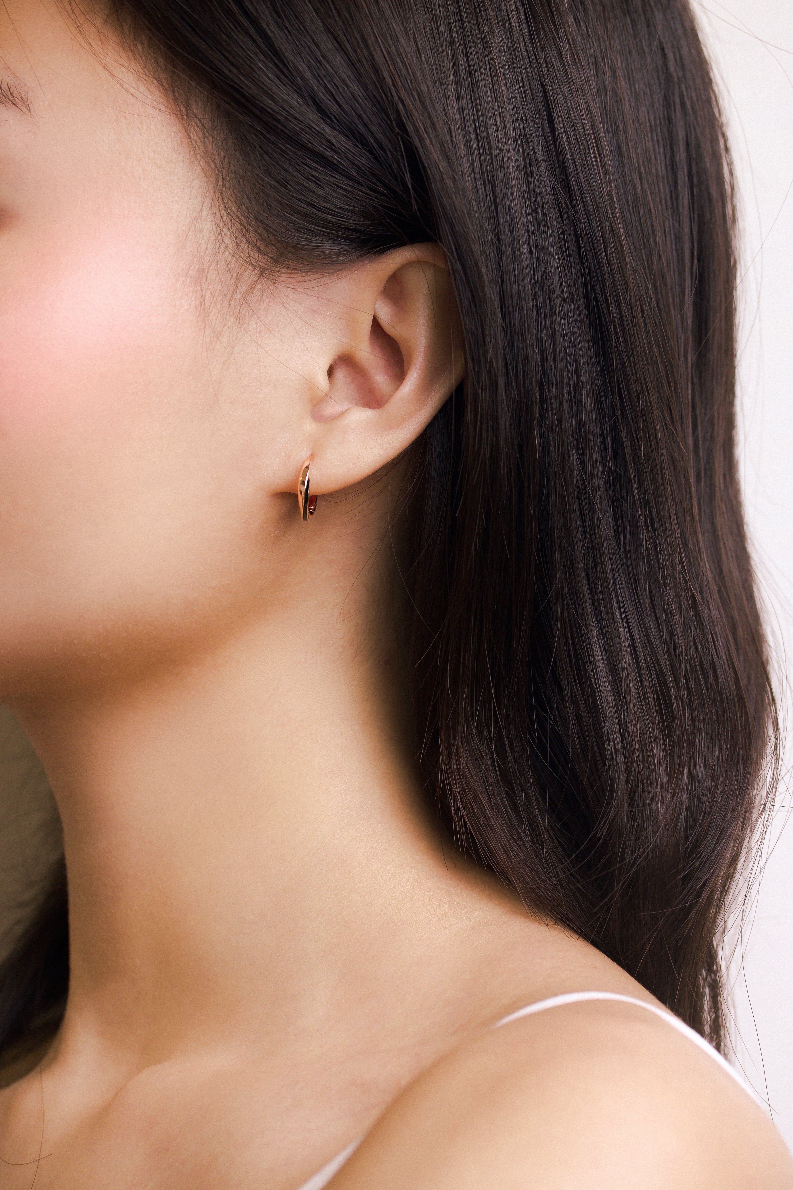 Fine jewellery, silver jewellery plated with rose gold, hypoallergenic, tarnish-free, close-up front view of a  Rose gold glazed black hoop earrings