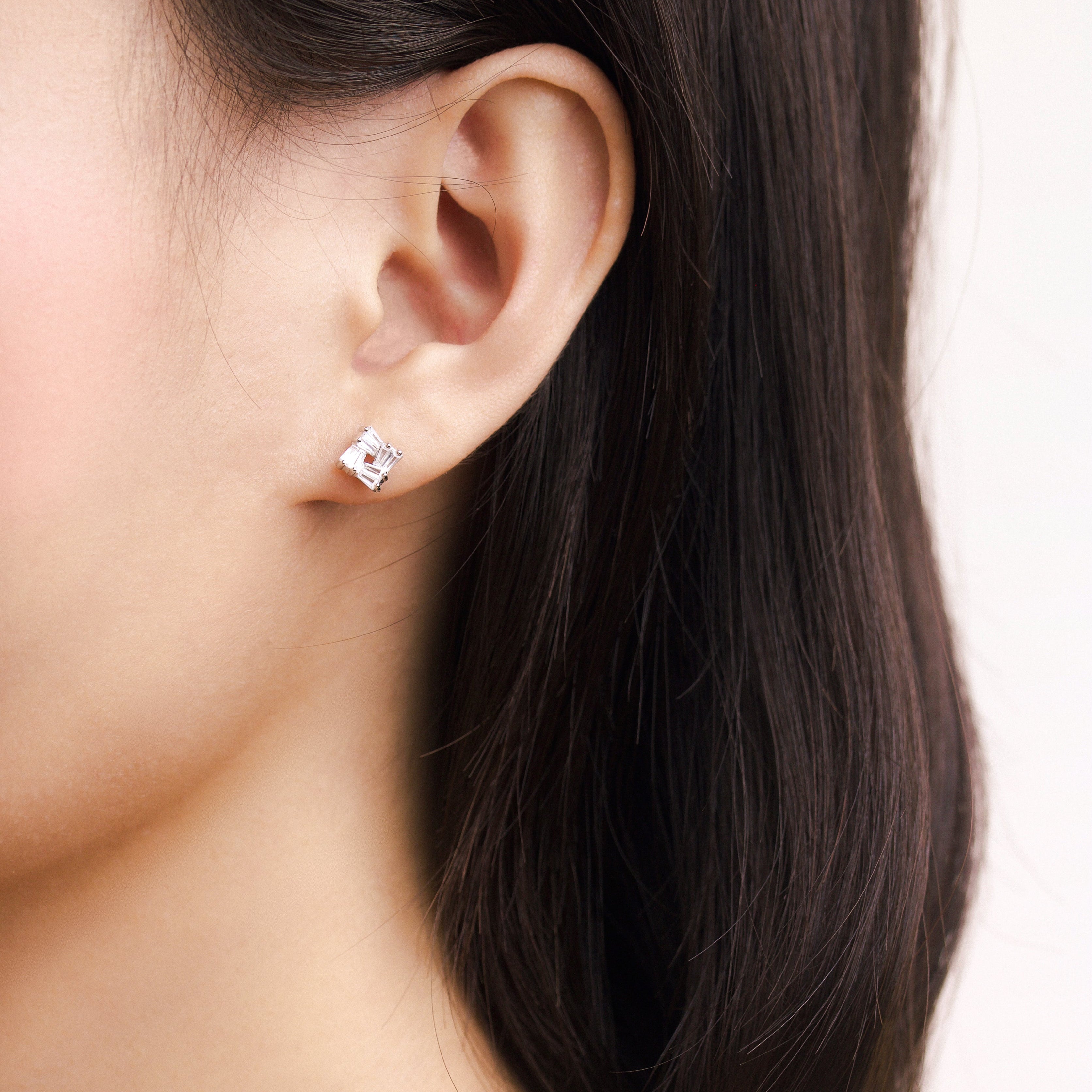Fine jewellery, silver jewellery, hypoallergenic, tarnish-free,
close-up side view of a silver square stud crystal earrings worn on a person's ear