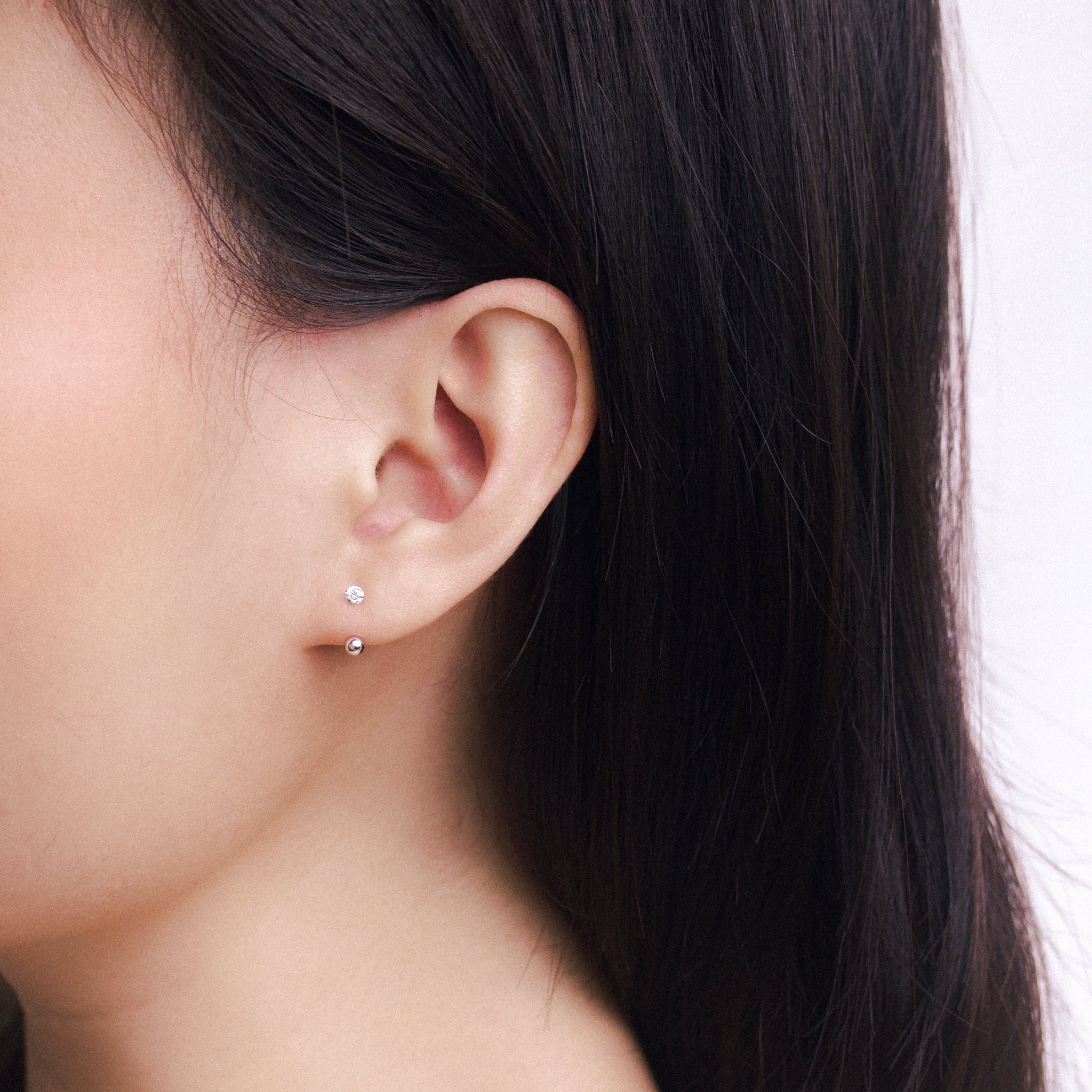 Fine jewellery, silver jewellery, hypoallergenic, tarnish-free, side full view of a person wearing a crystal earring with silver spherical ends