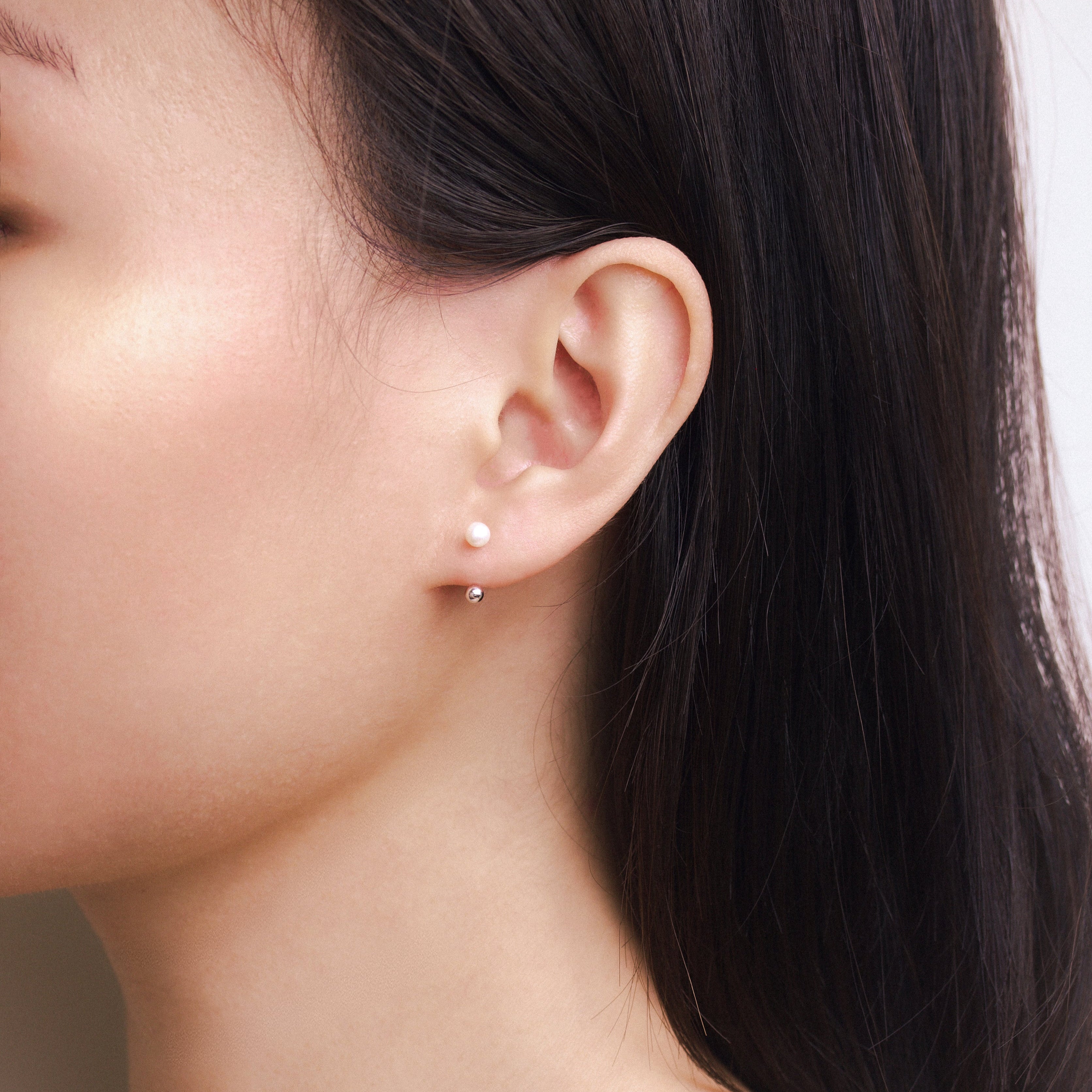 Fine jewellery, silver jewellery, hypoallergenic, tarnish-free, side full view of a person wearing a silver pearl earring 