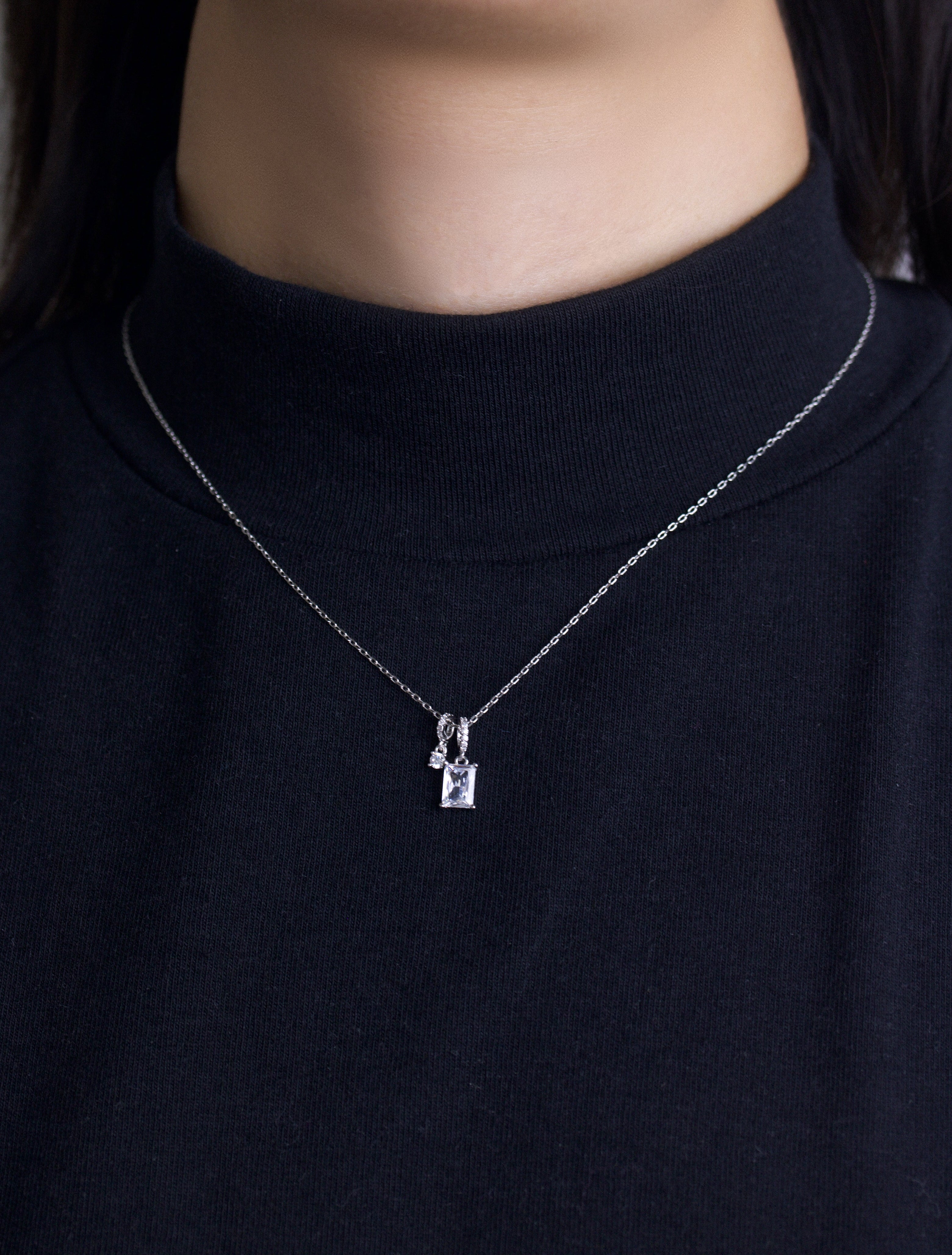 Fine jewellery, silver jewellery, hypoallergenic, tarnish-free, Front view of a Silver necklace with 2 crystal pendant on a person wearing a black sweater