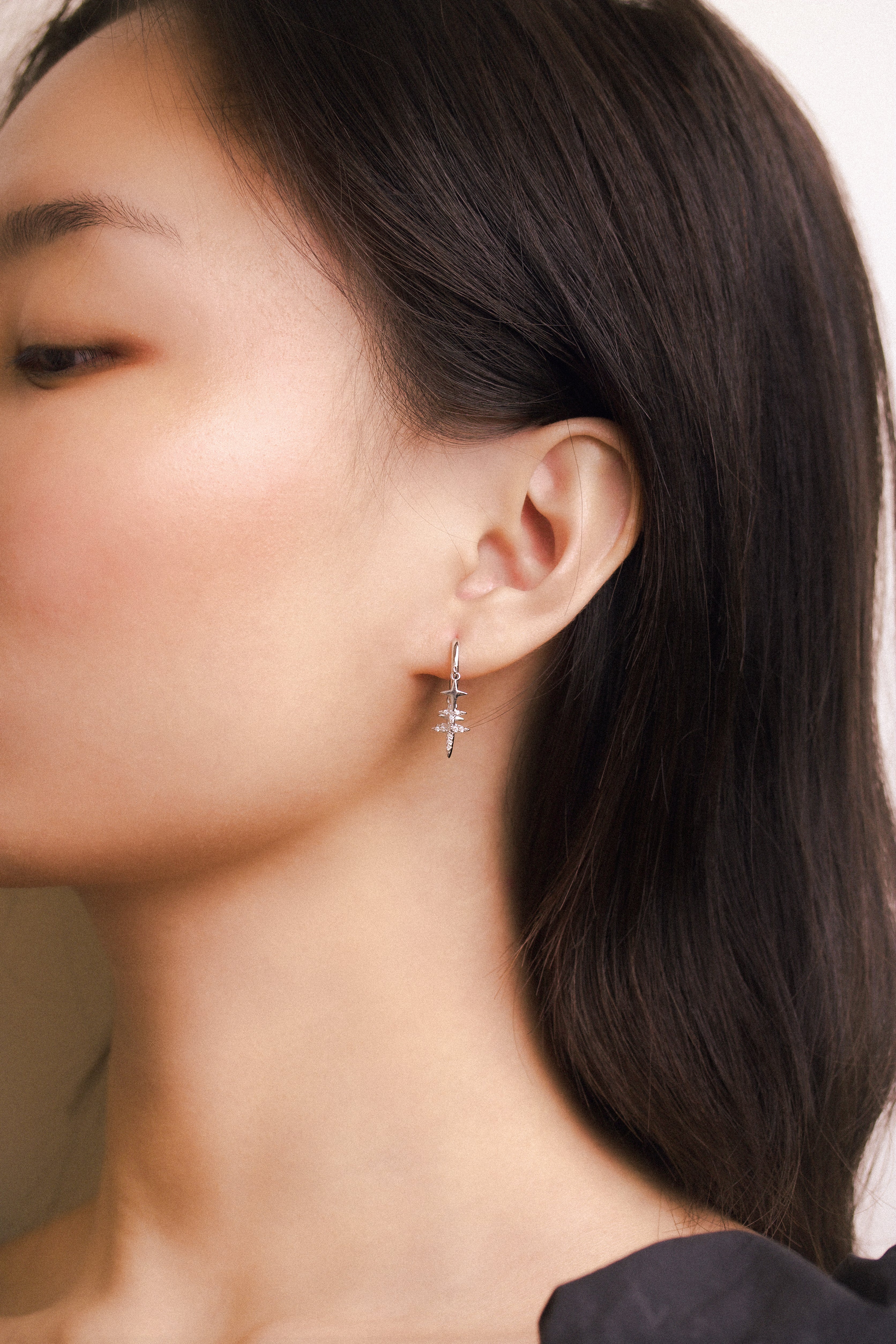 Fine jewellery, silver jewellery, hypoallergenic, tarnish-free,Side full view  of a silver star with crystal earrings worn on a person's ear