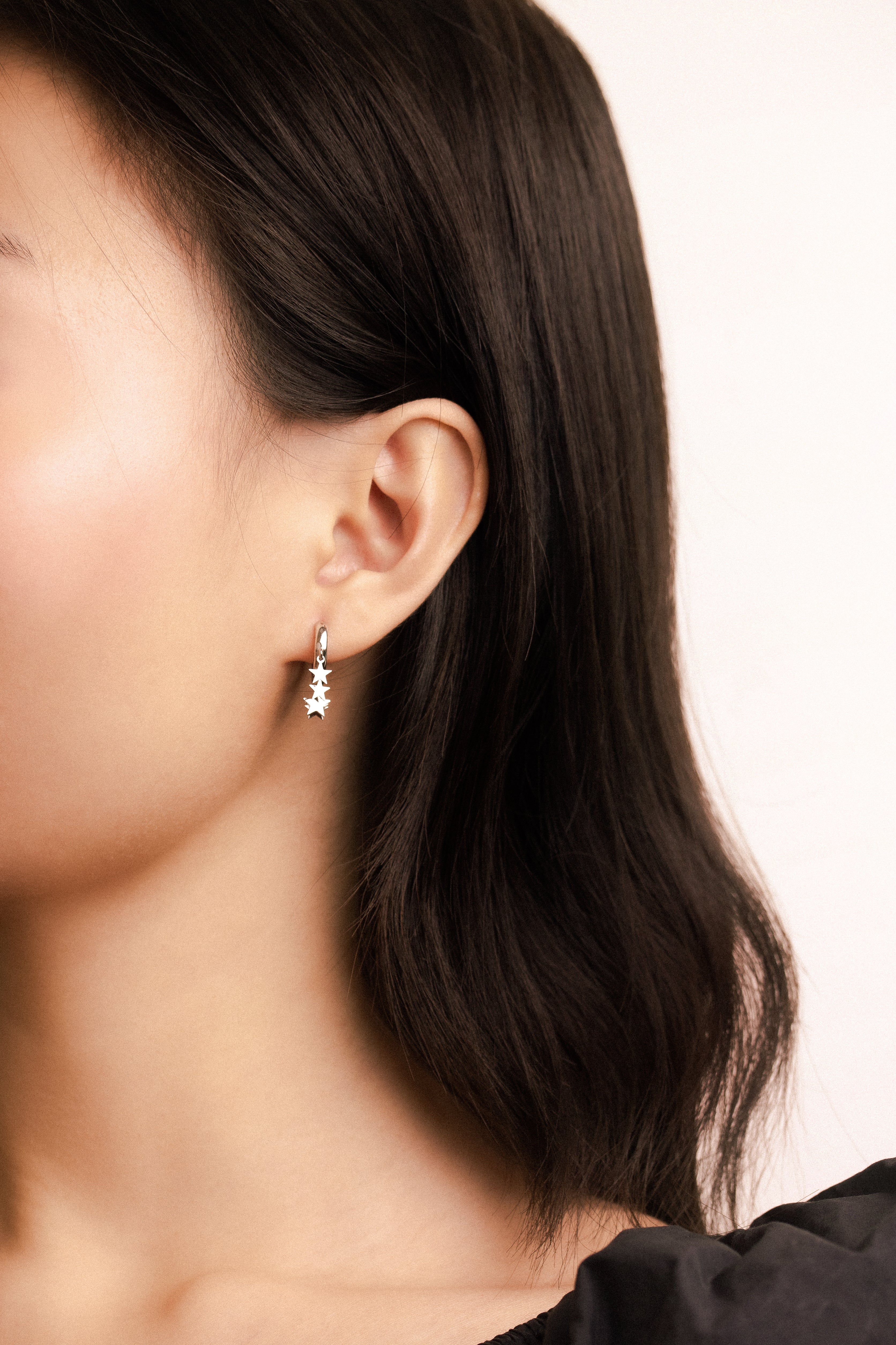 Fine jewellery, silver jewellery, hypoallergenic, tarnish-free, front full view of a person wearing a silver earring with a light background